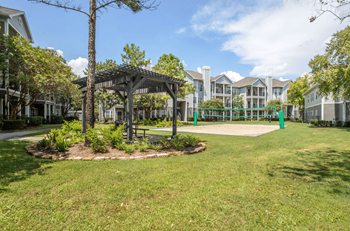 A tree-lined walkway leads to a building at Reserve by the Lake, Houston, TX